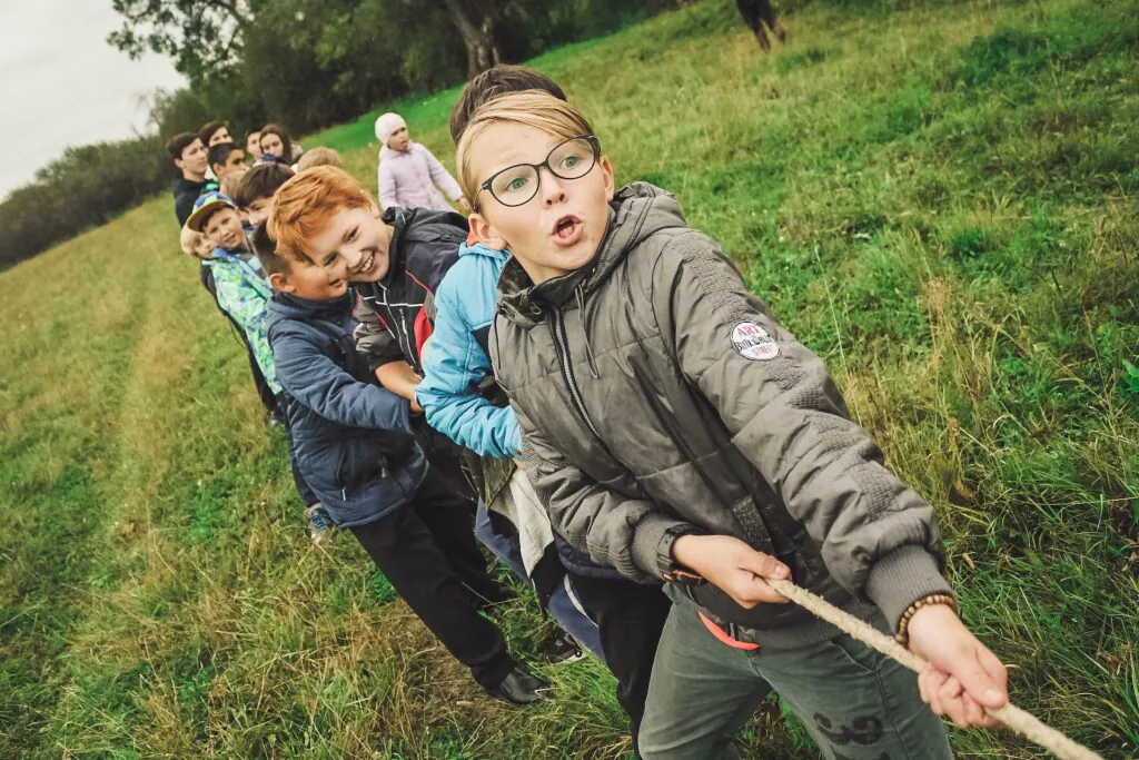 Izvedite dete napolje 3 deca povlace konopac